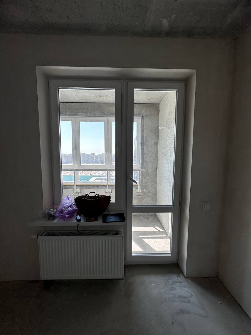 Комната до ремонта: панорамное окно и балконный блок, голые стены